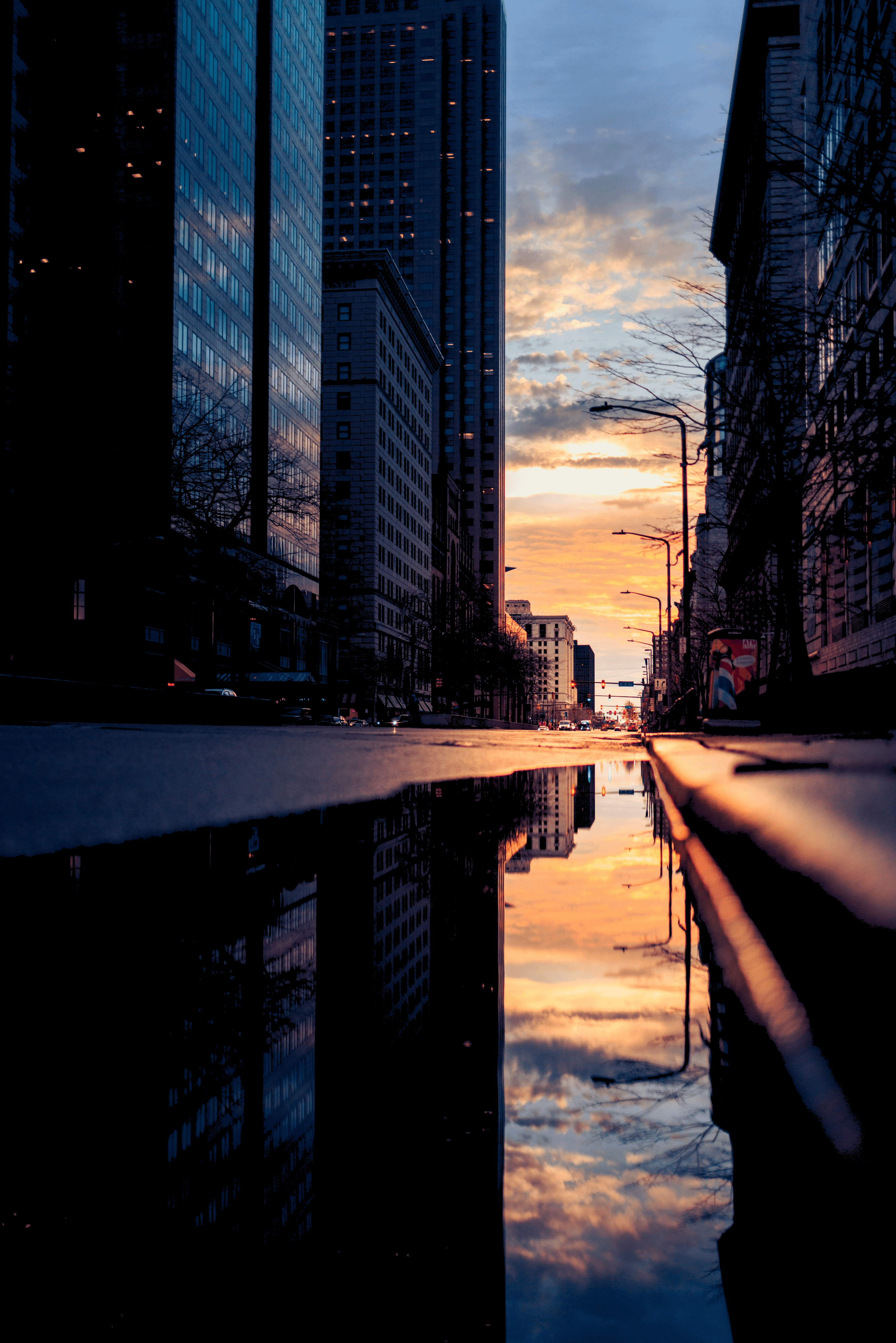 A city street with a reflection of buildings in the water amoled mobile 2k